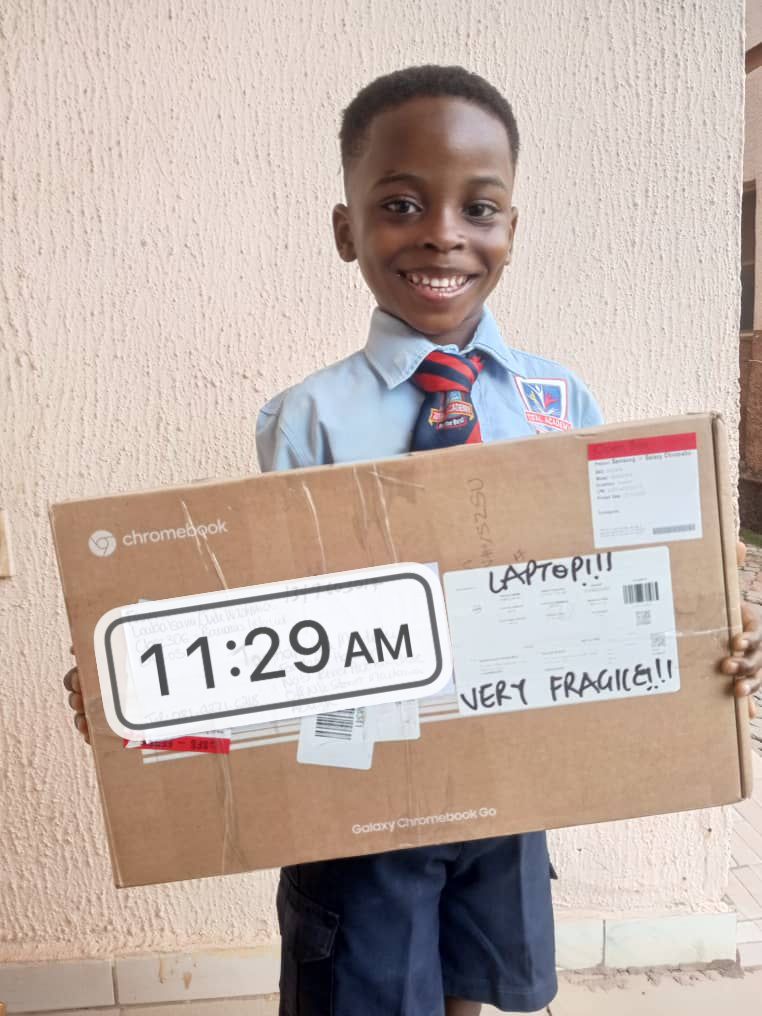 Yasir from Abuja holding his laptop package.