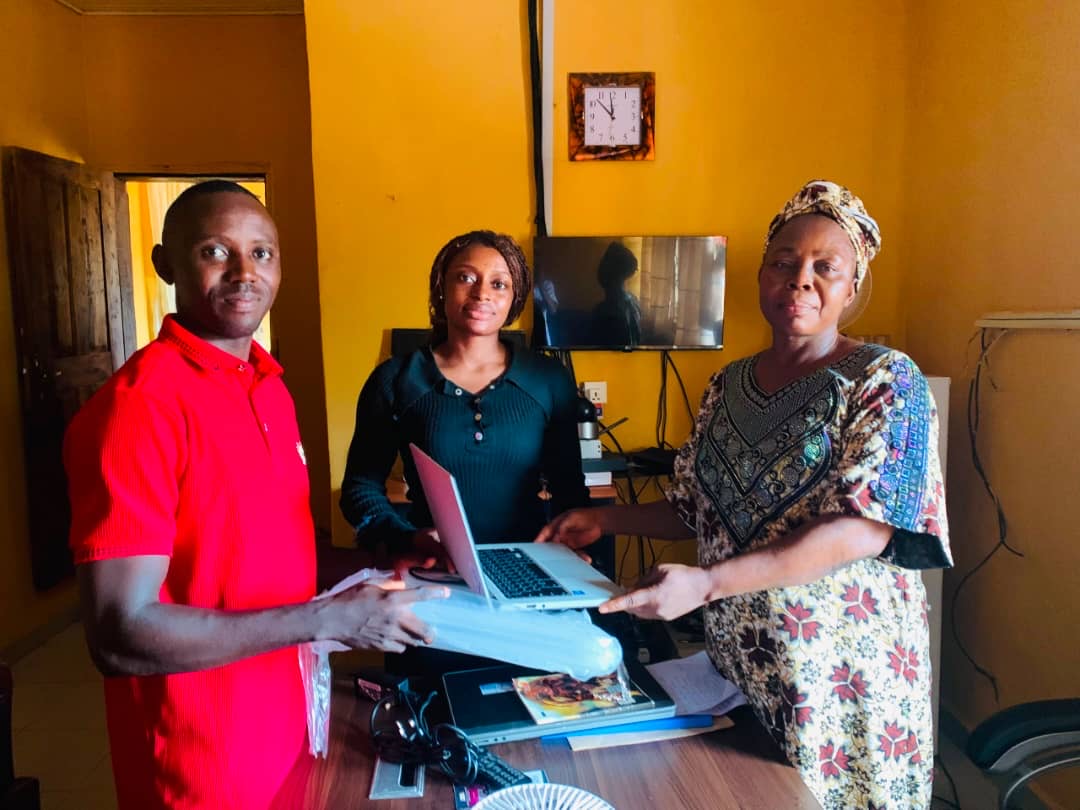 Joy Onuh Delight, first-place dance winner, receiving her laptop with State Coordinator Egbunu Odoma John and the Provost of the College of Nursing Sciences, Ochadamu.