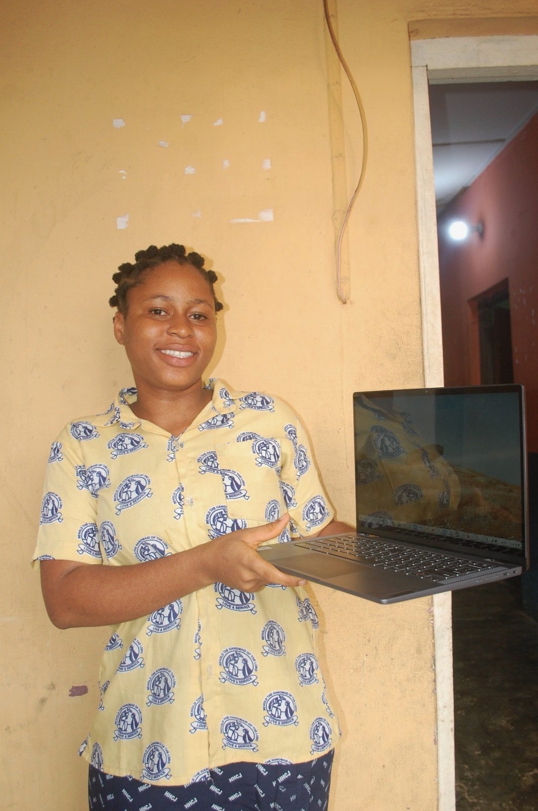 Karen from Oron, Akwa Ibom State, holding an open laptop.
